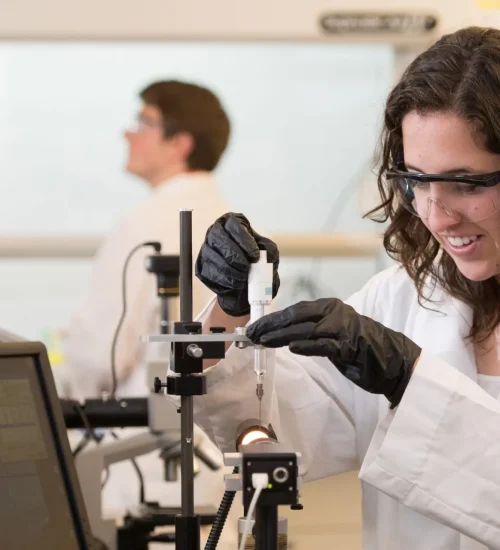 Researcher in a laboratory examining a sample with scientific equipment