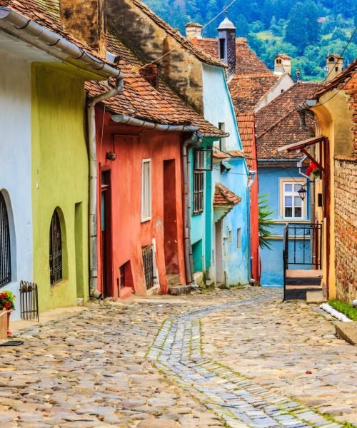 Colorful historic houses along a cobblestone street in Romania