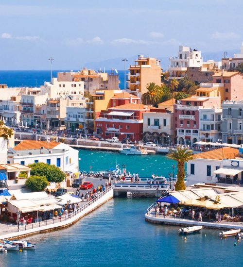 Coastal town in Crete with colorful buildings, marina and blue sea